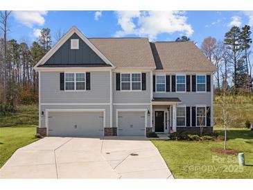 Charming two-story home with a two-car garage, manicured lawn, and classic architectural details at 3212 Burnello Ct, Iron Station, NC 28080