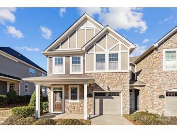 Charming two-story home featuring stone accents, a one-car garage, and a covered front porch, ideal for relaxing at 1114 Roderick Dr, Fort Mill, SC 29708