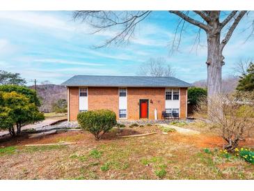 Charming brick home featuring a well-maintained lawn and an inviting red front door at 1285 Riverview Dr, Hickory, NC 28602