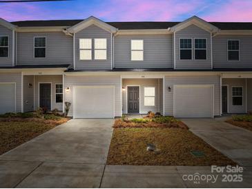 A daytime exterior shot of townhomes showing garage parking and craftsman style front doors at 140 S Bell Ave, Albemarle, NC 28001