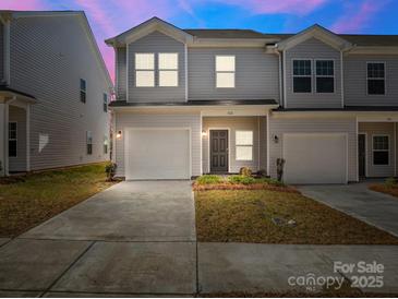 Charming townhome with a one car garage, well maintained lawn, and attractive front door at 142 S Bell Ave, Albemarle, NC 28001