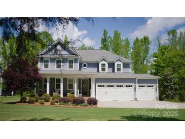 Charming two-story home featuring a well-manicured lawn and three-car garage at 158 Country Lake Dr, Mooresville, NC 28115