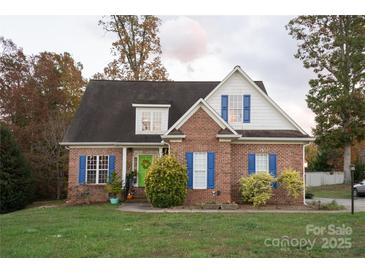 Charming brick home with blue shutters, dormer windows, a green door, and mature trees at 205 Kaitlyn Ln, Kings Mountain, NC 28086