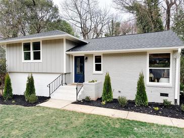 Charming renovated home with gray painted brick, black trim and a blue front door at 5057 Murrayhill Rd, Charlotte, NC 28210
