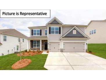 Charming two-story home with a two-car garage, a well-manicured lawn, and stone accents at 7015 Sylvan Retreat Dr, Denver, NC 28037