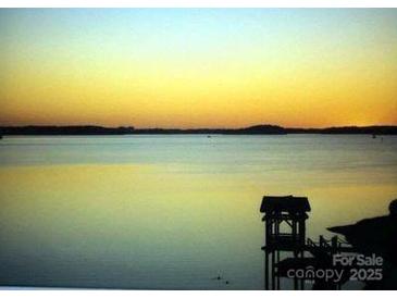 Picturesque lake view featuring a covered dock area at sunset at 17811 Half Moon Ln # C, Cornelius, NC 28031