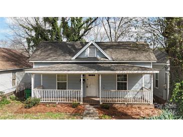 Charming one-story home featuring a covered front porch with white railings and mature trees at 314 Flint St, Charlotte, NC 28216