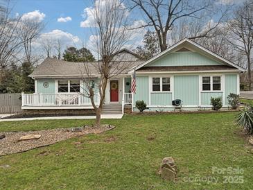 Charming home featuring a red front door, inviting porch, and well-manicured lawn at 5091 Windward Dr, Tega Cay, SC 29708