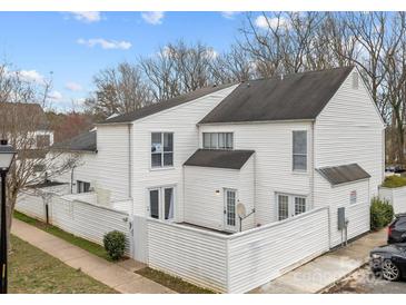 Charming two-story townhouse featuring white siding, a fenced patio, and well-maintained landscaping at 7138 Stonington Ln, Charlotte, NC 28227