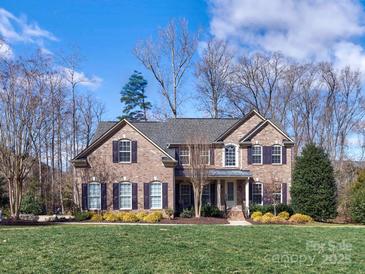 Beautiful two-story brick home with a well-manicured lawn and meticulously kept landscaping at 8017 Talcott Dr, Mint Hill, NC 28227
