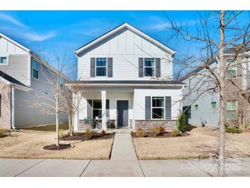 Charming two-story home with a welcoming front porch and professionally landscaped yard at 12425 Larue Ln, Huntersville, NC 28078