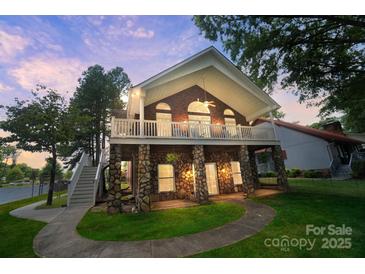 Stunning home exterior featuring a beautiful brick facade, stone accents, and a welcoming covered porch at 136 Nicks Rd, Norwood, NC 28128