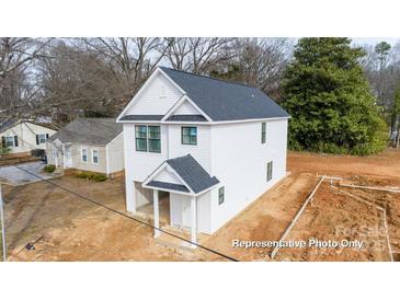 New construction home boasts a white exterior, dark roof, and inviting front porch; a blank canvas ready for your personal touch at 164 S Sycamore St, Mooresville, NC 28115