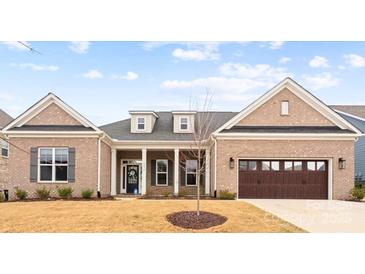 Charming brick home featuring an attached garage and a well-manicured lawn at 4034 Sagemont Nw Dr, Concord, NC 28027