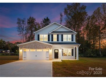 Charming two-story home with a well-maintained lawn and inviting entrance with beautiful architectural details at 8455 Old Plank Rd, Charlotte, NC 28216