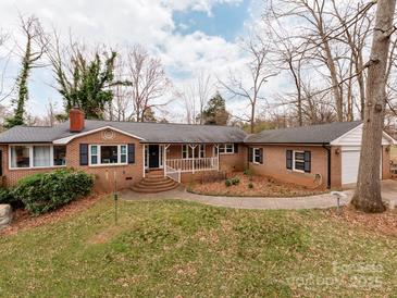 Charming one-story brick home with a welcoming front porch and landscaped yard at 9524 Fairlane Dr, Charlotte, NC 28214