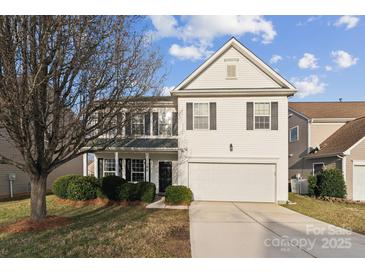 Charming two-story home featuring a pristine white exterior with a two-car garage and a well-manicured front yard at 1102 Less Traveled Trl, Indian Trail, NC 28079