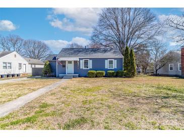 Charming blue single-story home with a manicured lawn, white trim, and an American flag at 1205 Poston Cir, Gastonia, NC 28054