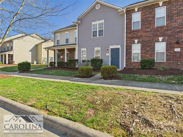 Charming townhome showcasing neat landscaping, and a mix of brick and siding at 128 Locomotive Ln # 110, Mooresville, NC 28115