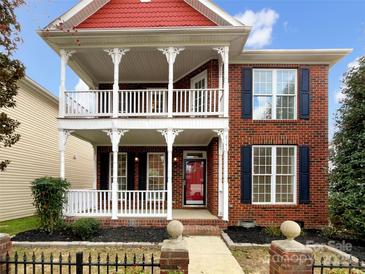 Charming red brick home boasts a double front porch, perfect for enjoying the outdoors at 6141 Creft Cir, Indian Trail, NC 28079