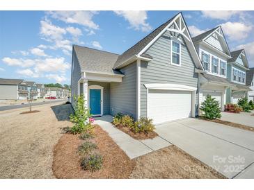 Charming home features a bright blue front door and a one car garage at 8573 River Ridge Dr, Charlotte, NC 28213