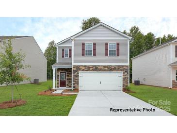 Charming two-story home featuring stone accents, a two-car garage, and a well-maintained lawn at 1026 Hostler Ln, York, SC 29745