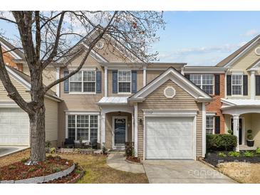 Charming two-story home featuring beige siding, blue shutters, and a well-manicured front yard with a driveway and garage at 11712 Huxley Rd, Charlotte, NC 28277