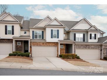 Charming townhome featuring a stone facade, attached garage, and landscaped front yard at 1915 Colony Line Ct, Charlotte, NC 28210