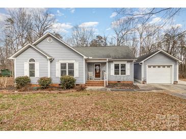 Charming one-story home with light blue siding, complemented by white shutters and a well-manicured front yard at 207 Cypress Dr, Gastonia, NC 28052