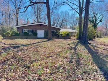 Charming brick ranch-style home with blue shutters and well-maintained landscaping at 2211 Unionville Indian Trl, Indian Trail, NC 28079