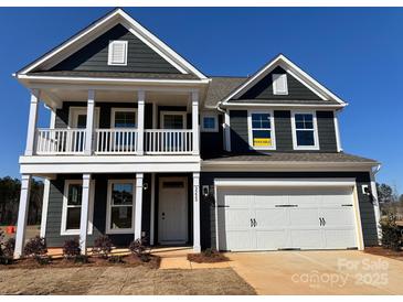 Charming two-story home features a welcoming porch, two-car garage, and a classic dark gray and white color scheme at 2228 Tabor Rd # 569, Sherrills Ford, NC 28673