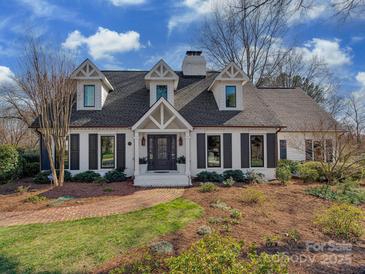 Charming white brick home with dormers, black shutters, and a brick walkway leading to the front door at 2326 Lathrop Ln, Charlotte, NC 28211