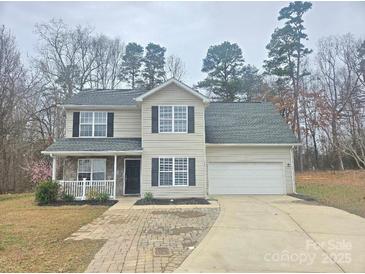 Charming two-story home with a well-manicured lawn, a front porch and an attached garage at 2766 Stagbuck Dr, Gastonia, NC 28052