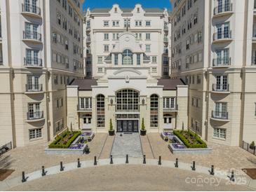 A beautiful, symmetrical exterior view of an elegant condo building with landscaped entrance and black iron accents at 2823 Providence Rd # 236, Charlotte, NC 28211