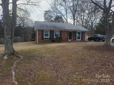 Charming single-story brick home with a well-maintained lawn and mature trees providing shade at 9808 Arbor Dale Ave, Charlotte, NC 28215