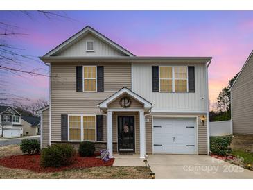 Charming two-story home featuring a well-maintained front yard and an attached garage at 1301 Waylon Ave, Gastonia, NC 28054