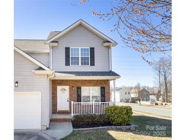 Charming two-story home with a brick facade, cozy front porch, and well-maintained landscaping at 136 Ridge Bluff Rd, Mooresville, NC 28115