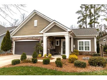 Charming single-story home with beautiful landscaping and a welcoming front porch at 16116 Lakeside Loop Ln, Cornelius, NC 28031