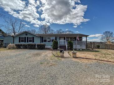 Charming single-story home with light blue siding, front porch, and gravel driveway at 170 Louise Dr, Mooresville, NC 28115