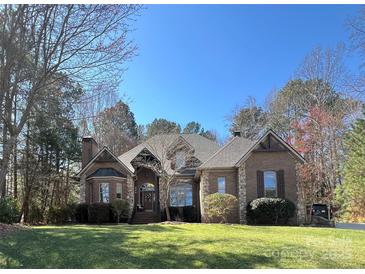 Brick and stone home with manicured lawn, mature trees, and a charming entrance at 2379 Metcalf Dr, Sherrills Ford, NC 28673