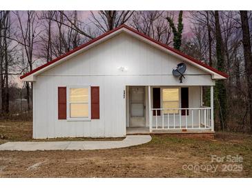 Charming one-story home featuring white siding, red roof, and a cozy front porch at 2407 Moose Rd, Kannapolis, NC 28083