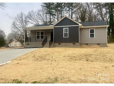 Charming single-story home features gray siding, a welcoming front porch, and a well-maintained yard at 519 N State St, Lincolnton, NC 28092