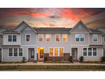 Charming townhome exterior featuring a brick foundation, complemented by a warm sky at sunset at 546 Amalfi Dr, Davidson, NC 28036