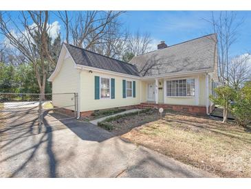 Charming yellow house with green shutters, fenced driveway, and a well-maintained front lawn at 6626 Somersworth Dr, Charlotte, NC 28215