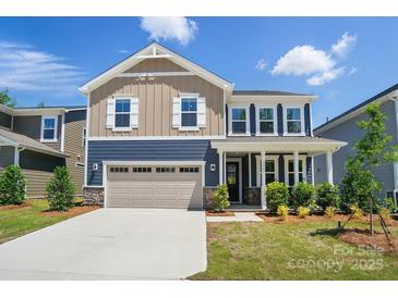 Charming two-story home featuring a two-car garage, manicured lawn, and beautiful curb appeal at 9843 Quercus Ln, Huntersville, NC 28078