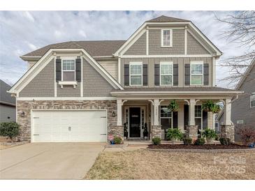 Charming two-story home showcasing a blend of stone and shingle siding and a welcoming front porch at 1048 Harbor Bay Dr, Indian Land, SC 29707