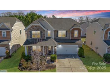 Beautiful two-story home with stone accents, manicured lawn, and a two-car garage at 1100 Wallace Lake Rd, Fort Mill, SC 29707