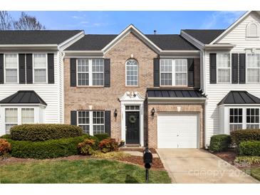 Inviting brick and siding townhome with black shutters, well-manicured landscaping and a one-car garage at 12031 Windy Rock Way # 1002, Charlotte, NC 28273