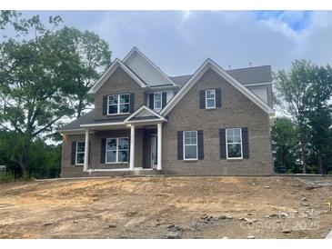 Charming two-story brick home featuring a covered front porch and classic architectural details at 2720 Old Course Rd, Monroe, NC 28112