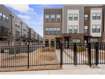 Modern townhome with a mix of brick and siding, complemented by a neat, fenced-in front yard at 3750 Ellington St, Charlotte, NC 28211